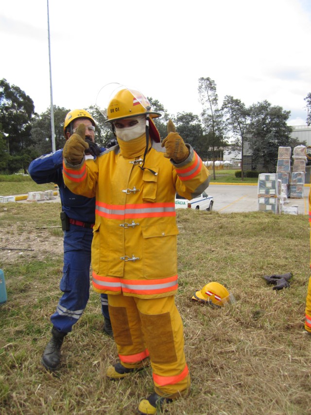 Yo aquí feliz y contento mientras uno de mis instructores me ayudaba con el traje. En ese momento no sabía lo que me esperaba tratando de moverme con ese traje, probando los extintores y corriendo con esas botas que pesan varios kilos, sin mencionar además el calor que da llevar todo eso encima.