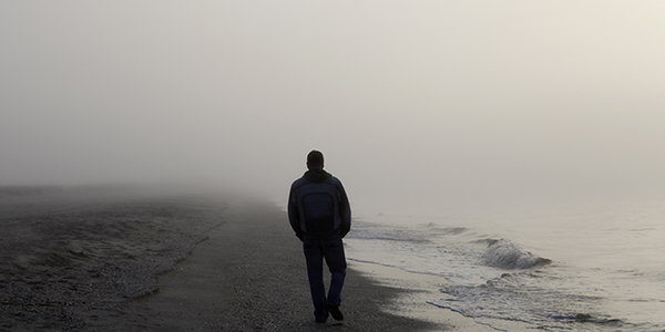 Lonely man walking on a beach